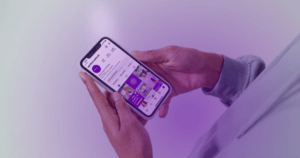 A photograph of someone holding an iPhone with the screen showing the SpinksCreative Instagram profile grid